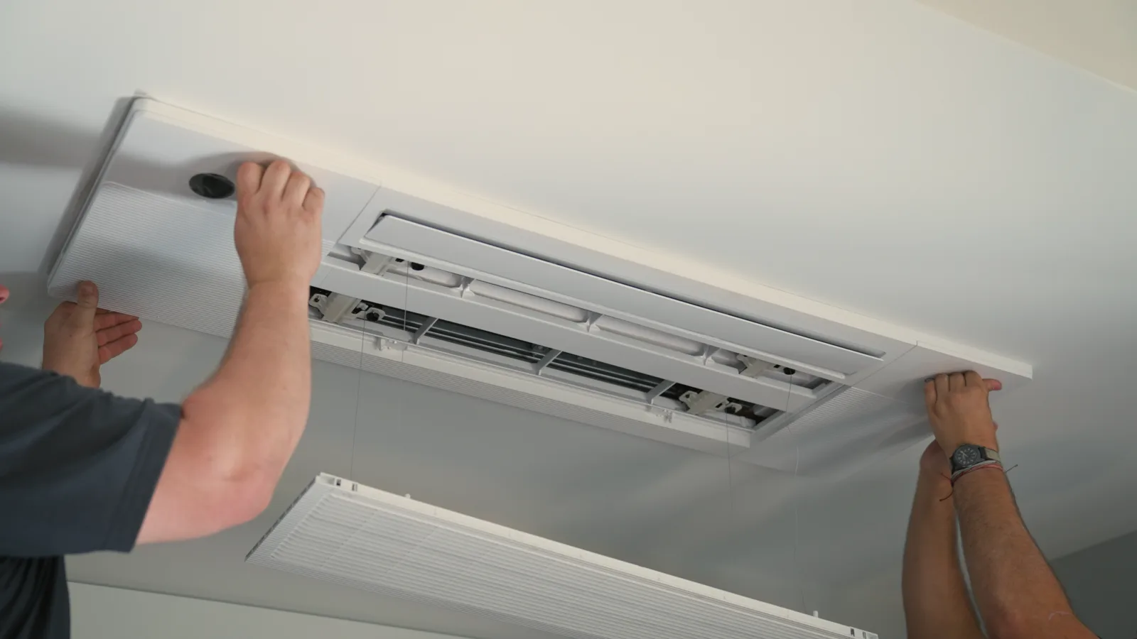 MC Electric technician installing wall-mounted mini split head in New England home